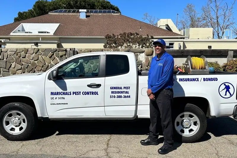 Marichal beside his branded work truck, providing professional pest control.